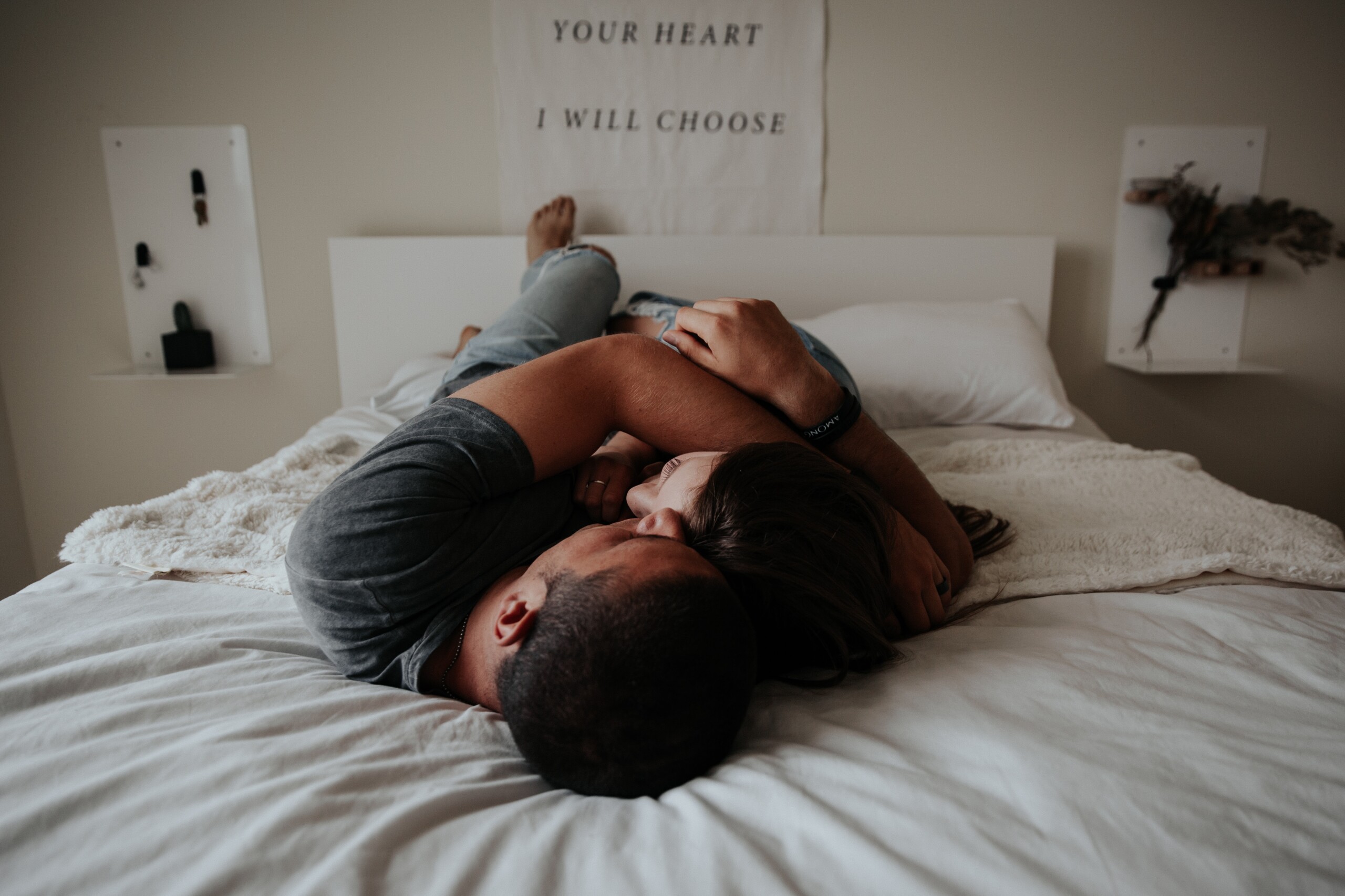 couple lying on bed in intimate embrace