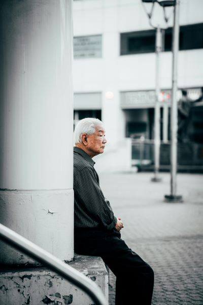 man sitting on curb staring into the distance